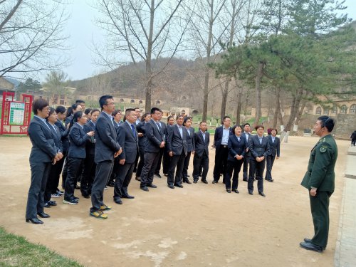 中国农业银行府谷支行的学员正在延安南泥湾炮兵学校听讲解员讲述炮兵学校的历史
